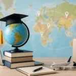 Globe, livres, valise et ordinateur illustrant les démarches pour étudier à l’étranger avec une traduction d’acte de naissance.