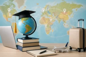 Globe, livres, valise et ordinateur illustrant les démarches pour étudier à l’étranger avec une traduction d’acte de naissance.
