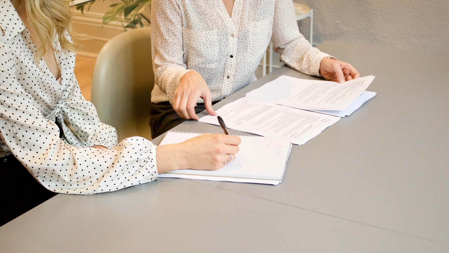 Professionnelles examinant et signant des documents pour illustrer la traduction juridique et d’entreprise à Bourges
