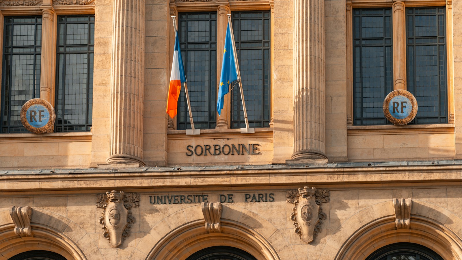Façade de la Sorbonne à Paris avec des drapeaux français